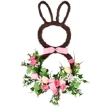A decorative wreath shaped like a bunny with two pink bows, adorned with pink flowers, greenery, and small eggs.