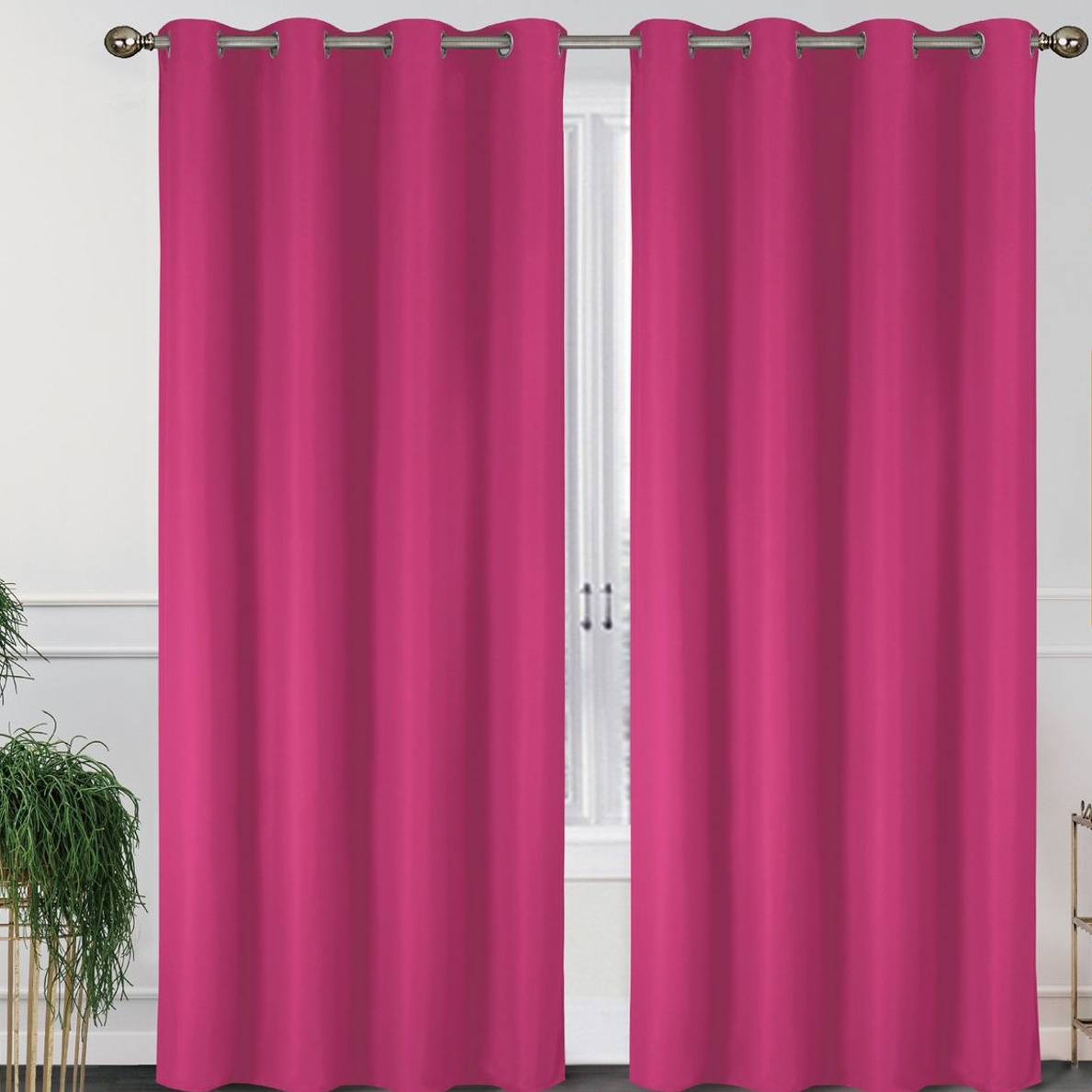 Two pink thermal blackout curtains are hanging on a rod against a white background, with a window and plants visible in the corners.