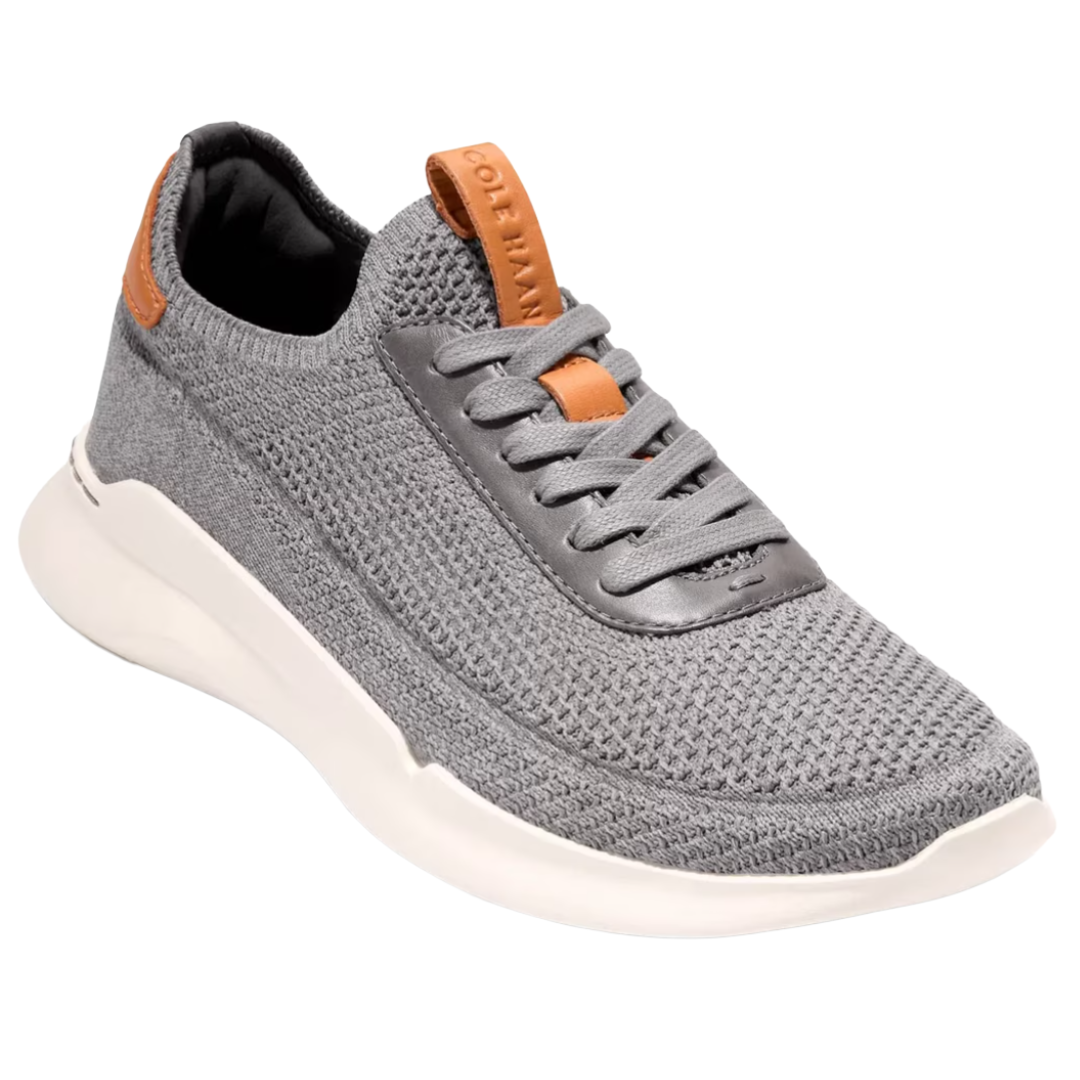 A gray knit sneaker with brown accents, featuring a white sole and lace-up design.