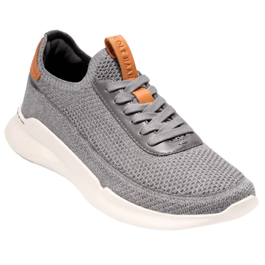 A gray knit sneaker with brown accents, featuring a white sole and lace-up design.