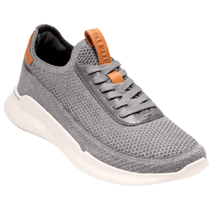 A gray knit sneaker with brown accents, featuring a white sole and lace-up design.