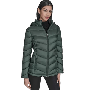 A woman is wearing a dark green, quilted puffer jacket with a hood, zipped front, and side pockets, paired with black pants.