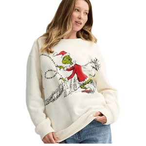 Cream-colored fleece pullover featuring the Grinch in a Santa outfit, holding a string of colorful Christmas lights, paired with casual jeans.