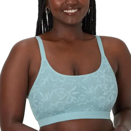 A woman wearing a light blue, floral-patterned bra, with adjustable straps and a supportive underband.
