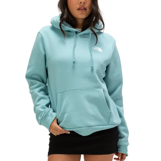 A woman is wearing a light blue North Face hoodie with a kangaroo pocket and drawstring hood, paired with a black skirt.