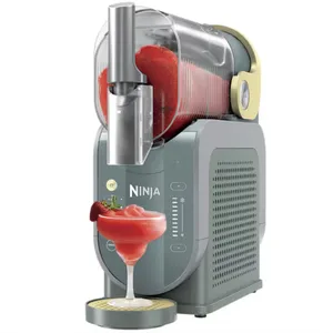 A Ninja drink machine dispenses a strawberry slushy into a martini glass, featuring a transparent container and control panel on the front.