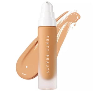 Fenty Beauty liquid foundation with a smooth, tan shade, housed in a sleek bottle with a pump dispenser.