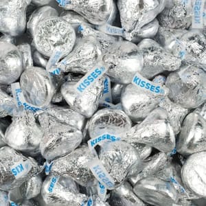 5lbs of Hershey's Kisses, wrapped in silver foil with a distinctive paper plume labeled \“KISSES,\“ scattered in a pile.