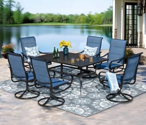 A patio set with six dark blue swivel chairs and a long rectangular table, displayed outdoors near a body of water.