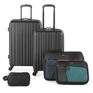 A set of black luggage including two hard-shell suitcases, packing cubes for organizing clothing, and a toiletry bag.
