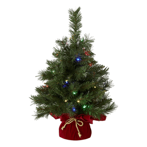 A small artificial Christmas tree decorated with multicolored lights, set in a red base cover tied with a gold ribbon.