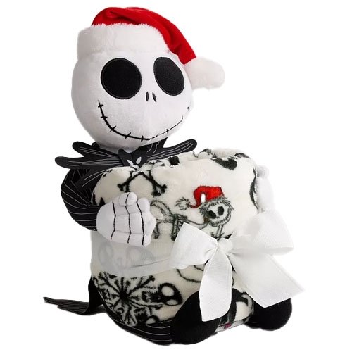 A plush figure wearing a Santa hat sits alongside a fleece blanket featuring skull and snowflake patterns, both tied together with a white ribbon.