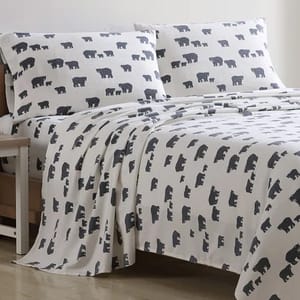 A bed set featuring white sheets with a pattern of dark gray bear silhouettes, including a fitted sheet, flat sheet, and two pillowcases.