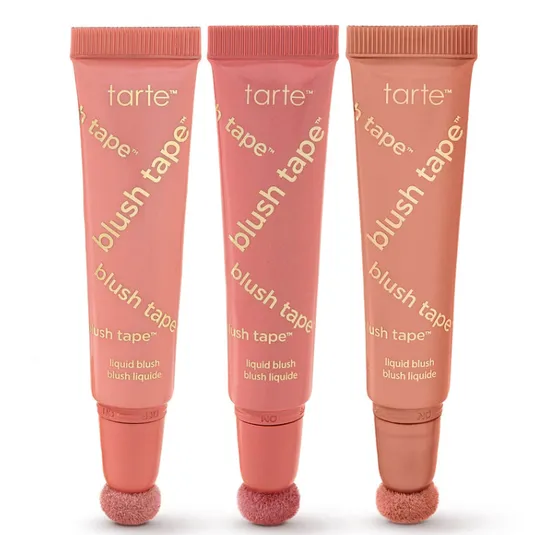 Three tubes of Tarte Blush Tape liquid blush with sponge applicators, in varying shades of pink and peach.