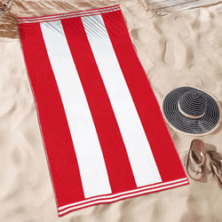 Red and white striped beach towel on sand, accompanied by a black and white wide-brimmed hat and a pair of sandals.