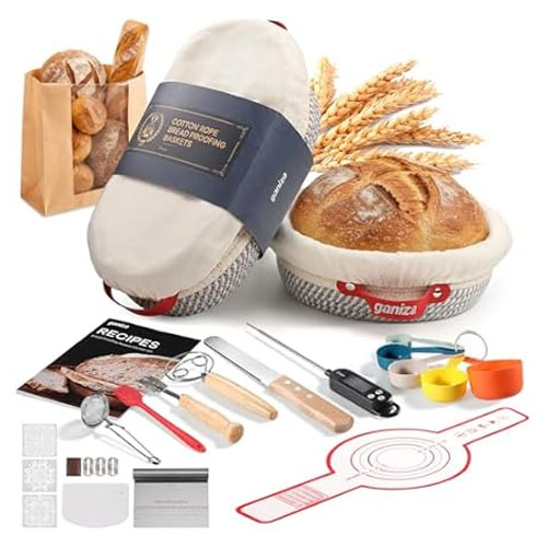 Bread-making kit featuring banneton baskets with liners, recipe book, bread scoring tool, whisk, bread lame, dough scraper, measuring cups, spoons, and a silicone baking mat.