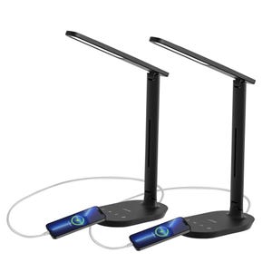 Two black desk lamps with adjustable arms feature built-in charging ports at the base, where smartphones are connected via charging cables.