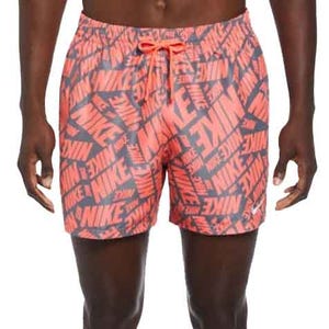 Nike men's swim trunks feature a bold all-over logo pattern in red and dark blue, with an elastic waistband and adjustable drawstring for a secure fit.