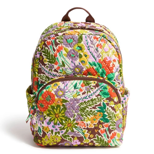 A quilted backpack featuring a colorful floral pattern with a variety of flowers and leaves, including a front zip pocket and side pockets.