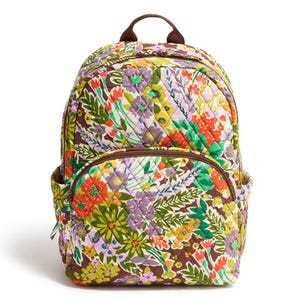 A quilted backpack featuring a colorful floral pattern with a variety of flowers and leaves, including a front zip pocket and side pockets.