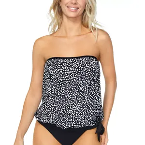 A woman is wearing a strapless, polka-dotted tankini top with a tie detail on the side, paired with black bikini bottoms.