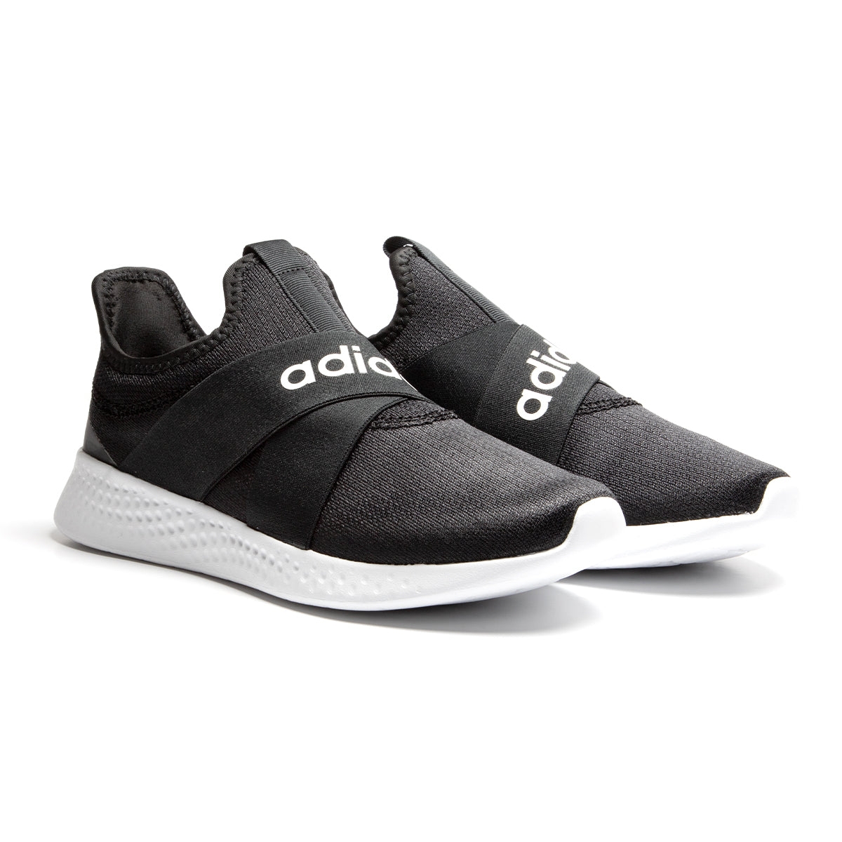 A pair of black Adidas Puremotion shoes with white soles, featuring slip-on design and prominent Adidas branding on the front strap.