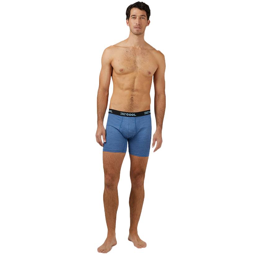 A man wearing blue boxer briefs with a black waistband labeled \“32 DEGREES COOL.\“