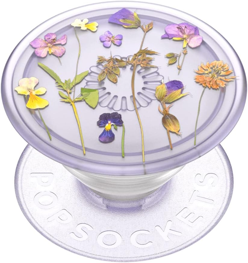 A PopSocket with a clear top featuring a design of pressed flowers, showcasing various colorful blooms on a light purple background.