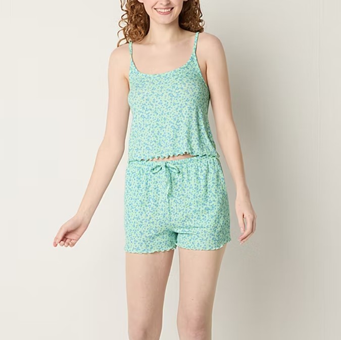 A woman models a blue floral sleeveless top with matching shorts.