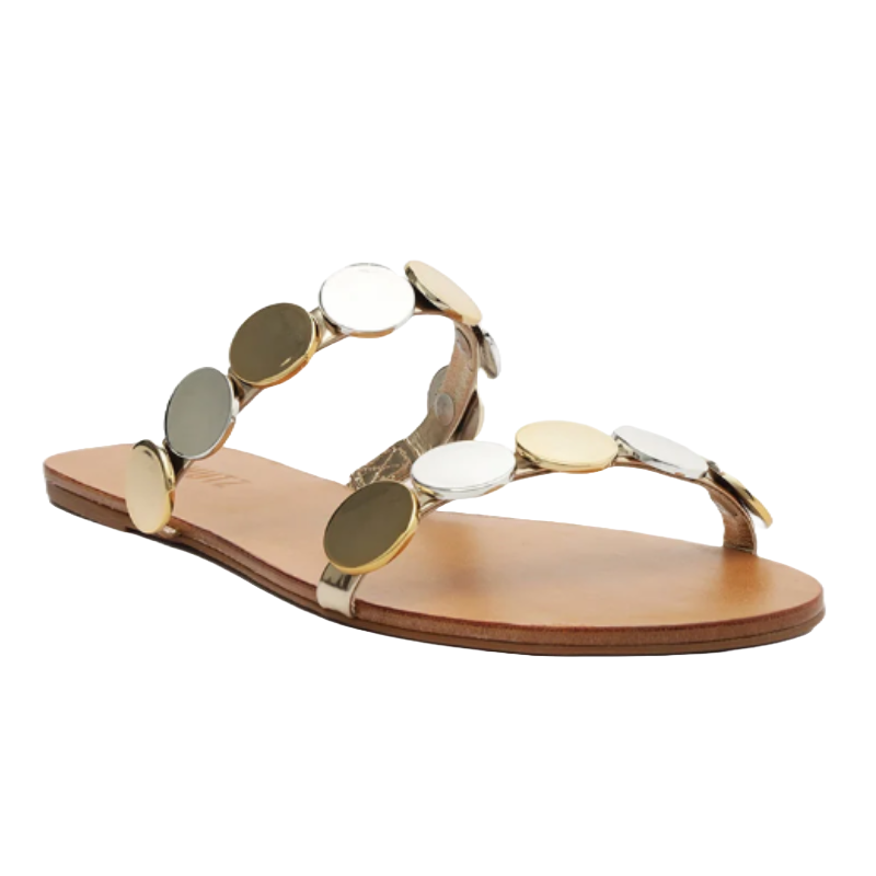 A flat sandal featuring a tan sole and two metallic straps adorned with large round discs in silver and gold tones.