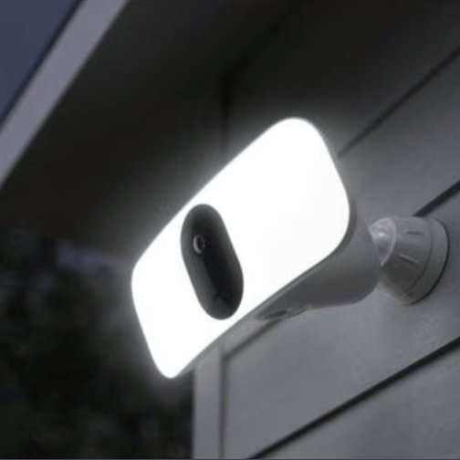 A wall-mounted outdoor security light with a built-in camera, featuring a bright, rectangular LED panel for illumination.