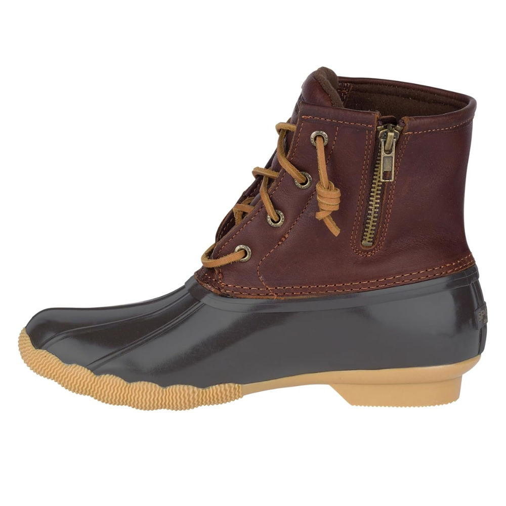 A leather and rubber duck boot with a side zipper and lace-up front, featuring a brown upper, black waterproof lower, and tan rubber sole.