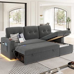 A gray sectional sofa with a pull-out bed and storage compartment. It features stud detailing, built-in lights, and a charging station with pockets for devices and magazines.