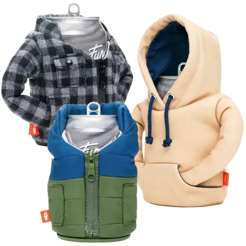 Three beverage cans are dressed in miniature outfits: a black-and-gray flannel shirt, a beige hoodie with a blue interior, and a blue and green zip-up jacket.