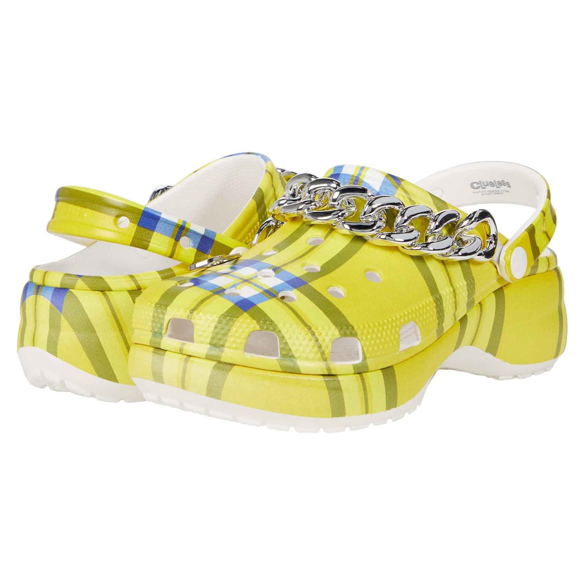 Yellow clogs featuring a Clueless-inspired plaid pattern, with perforated details and embellished with a silver chain across the top.