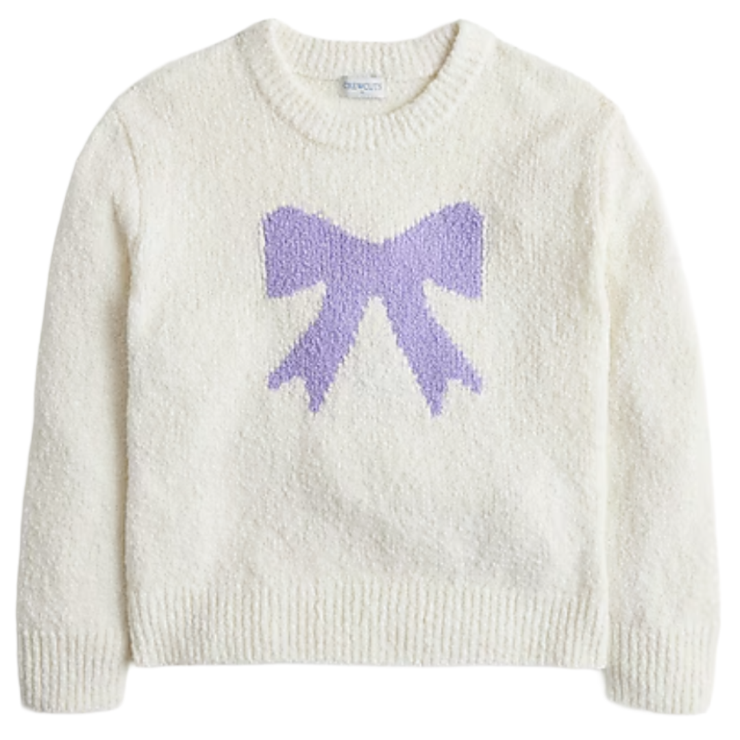 A cozy white sweater features a large purple bow design on the front, with a ribbed crew neck, cuffs, and hem.