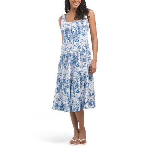 Blue and white A-line Nicole Miller midi dress featuring a sleeveless design with a subtle abstract pattern, slightly flared skirt, and a square neckline. The model is wearing white sandals for a casual look.