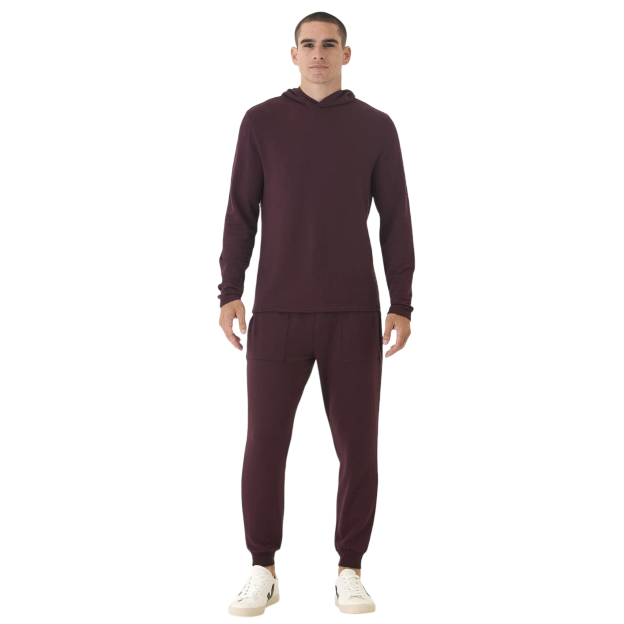 A person is wearing a matching maroon long-sleeve hoodie and jogger pants set, paired with white sneakers.