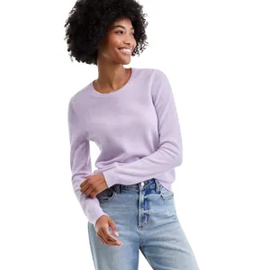 A person wearing a light purple sweater paired with light blue jeans, smiling and looking to the side.