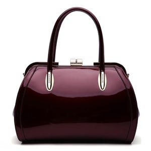 A glossy burgundy handbag with dual handles and a metal clasp.