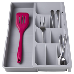 Gray cutlery organizer tray with multiple compartments, housing a red spatula, forks, and spoons.