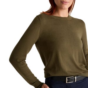 A woman wearing an olive green crewneck sweater and a dark belt with a silver buckle.