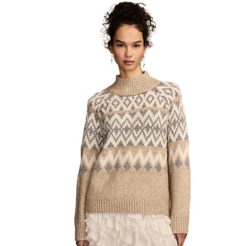 A woman wears a beige and gray patterned fair isle sweater with a ribbed turtleneck, paired with a white ruffled skirt.