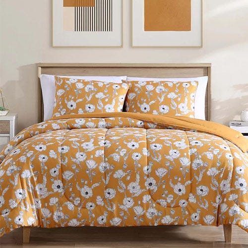 a three piece comforter set with white flowers on a yellow background