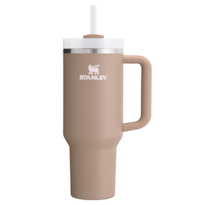 A beige Stanley Quencher Tumbler with a 40oz capacity features a handle, a screw-on lid, and a straw. It is designed for both hot and cold beverages.