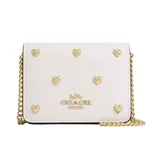 White Coach wallet with gold heart embellishments and a gold chain strap.
