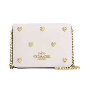 White Coach wallet with gold heart embellishments and a gold chain strap.