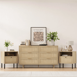 Light wood dresser with woven drawers and matching side tables; each is topped with vases of flowers, books, and a lamp. A framed Keith Haring poster decorates the top of the dresser.