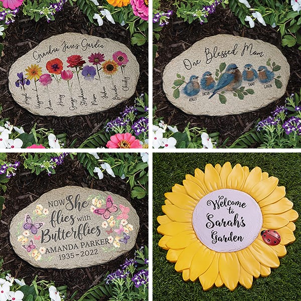 Four decorative garden stones with personalized messages and designs: one with colorful flowers, another with bluebirds, a butterfly-themed memorial stone, and a sunflower-shaped stone with a ladybug. Each stone is surrounded by vibrant flowers.