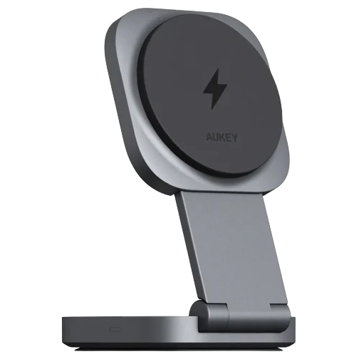 A silver and black AUKEY wireless charging stand with a foldable design and a lightning bolt symbol, suitable for propping up devices while charging.